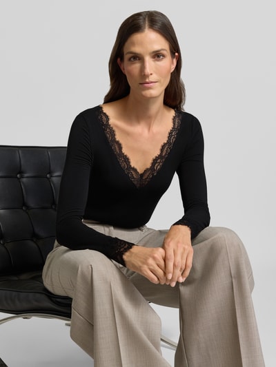 Kobiece model prezentuje czarną bluzkę z długim rękawem z mieszanki modalu i wełny model 'SKYE' od VERO MODA, damska bluzka z długim rękawem, widok na górną część ciała z przodu.