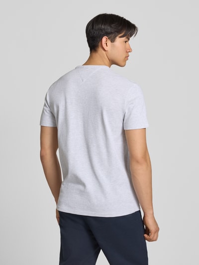 Männermodel trägt Regular Fit T-Shirt aus Baumwoll-Mix von Tommy Jeans in Unifarben mit Logo-Stitching, Ganzkörperansicht Rückansicht.