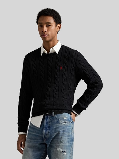 Męski model nosi Regular Fit Strickpullover aus reiner Baumwolle od Polo Ralph Lauren w kolorze czarnym, wzór warkoczowy, detal logo, dekolt okrągły, długie rękawy, dzianina, czysta bawełna, gładka faktura; ujęcie: całkowita widoczność z przodu.