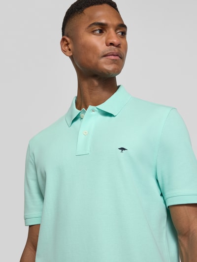 Männermodel trägt Regular Fit Poloshirt mit Logo-Stitching von Fynch-Hatton in Mintgrün, reine Baumwolle, Nahaufnahme Oberkörper.