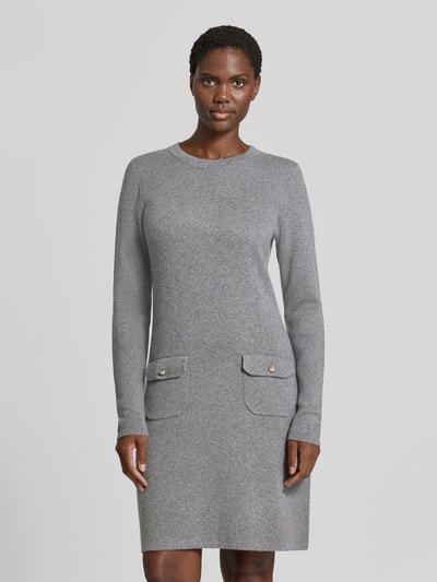 Frauenmodel trägt figurbetontes Freizeitkleid mit Viskose-Woll-Kaschmir-Anteil Modell '264KN32Kasta' von JOOP!, grauer Farbton, strukturierte Oberfläche, zwei aufgesetzte Taschen, Damen Freizeitkleid von JOOP!, Ganzkörperansicht von vorne.