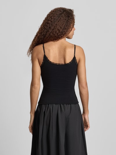 Frauenmodel trägt Slim Fit Top mit Spitzenbesatz von REVIEW in Schwarz, reine Baumwolle, Spaghettiträger, Zierschleifen, Ganzkörperansicht Rückansicht.