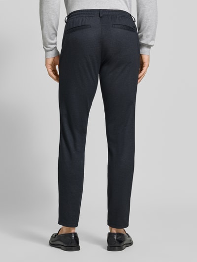 Männermodel trägt dunkelblaue Tapered Fit Jogpants mit Viskose-Anteil Modell 'Phil' von Brax, Herren Weite Hose, Ganzkörperansicht Rückansicht.