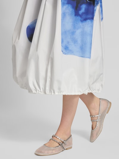Frauenmodel trägt Midi-Rock aus reiner Baumwolle Modell 'GEYSER' von MAX&Co., weiß mit blauem Allover-Muster, elastischer Bund und Saum, seitliche Eingrifftaschen, Loose Fit, Midilänge, Ganzkörperansicht von vorne