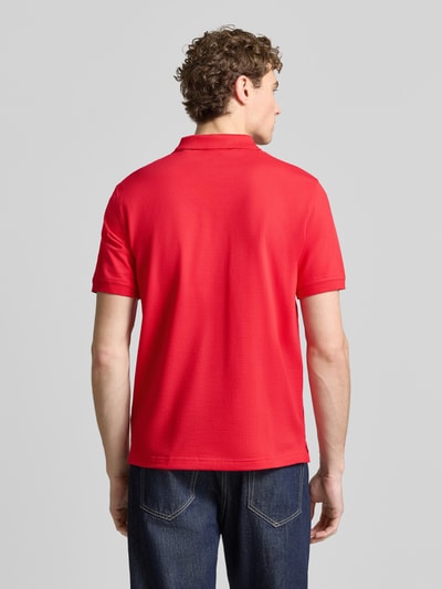 Männermodel trägt Regular Fit Poloshirt mit Logo-Stitching von Gant in Rot, elastischer Baumwoll-Mix, Kurzarm, Ganzkörperansicht Rückansicht.