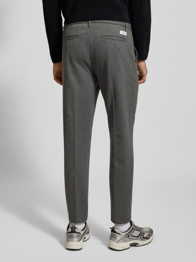 Männermodel trägt Regular Fit Bundfaltenhose mit Viskose-Anteil von Marc O'Polo Denim, Optik: Unifarben, Passform: Regular-Fit, Details: Bundfalte, Gürtelschlaufen, Bügelfalten, Verschluss: Tunnelzug, Knopf und verdeckter Reißverschluss, Bundabschluss: elastisch, Taschen: seitliche Eingrifftaschen, Gesäßtaschen, Farbe: Grau, glatte Struktur, Ganzkörperansicht Rückansicht.