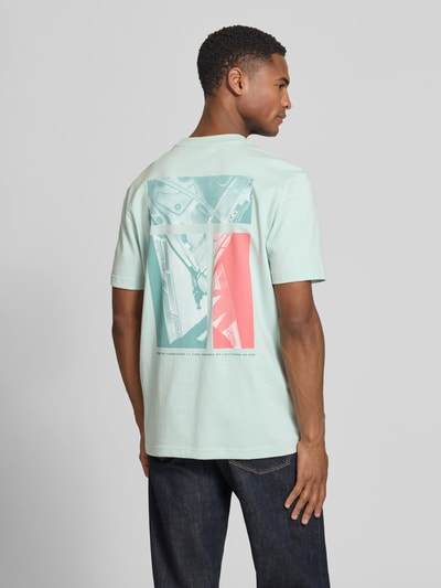 Mannelijk model draagt Regular Fit T-Shirt uit zuiver katoen model 'TE_GROOVE' van BOSS Orange, effen, foto-print, jerseystructuur, rondhals, korte mouw, labelapplicatie, zijaanzicht van achteren.
