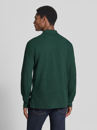 Męski model nosi Regular Fit Poloshirt aus reiner Baumwolle von Polo Ralph Lauren w kolorze ciemnej zieleni, gładka faktura, całkowity widok od tyłu.