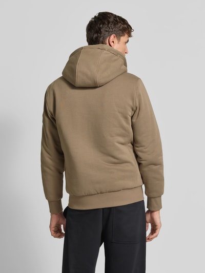 Männermodel trägt Sweatjacke aus Baumwoll-Mix von Moose Knuckles in Beige mit körpernaher Passform, Plüschfutter und Kängurutasche, Ganzkörperansicht Rückansicht.