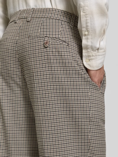 Männermodel trägt Hose mit Gesäßleistentaschen Modell 'WYACO' von DRYKORN, feines Karomuster, Beige und Braun, Nahaufnahme Rückansicht. Bundweite und Innenbeinlänge laut Kontext.