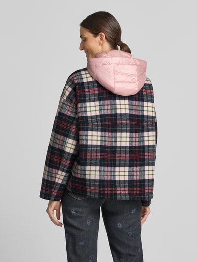 Frauenmodel trägt Regular Fit Jacke mit Kapuze von Marc Cain, kariertes Muster in Dunkelgrün, Rosa und Creme, Zweiwege-Reißverschluss, Tunnelzug, Rückenlänge 65 cm, Schulterbreite 59 cm, Brustweite 63 cm, Ärmellänge 50 cm, Ganzkörperansicht Rückansicht.