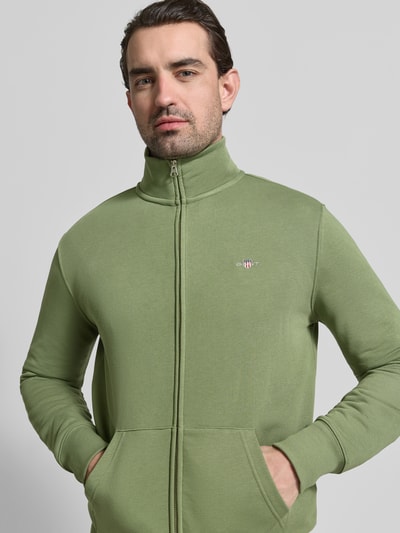Männermodel trägt Regular Fit Sweatjacke mit Stehkragen Modell 'Gield' von Gant in Grün, Logo-Stitching, Baumwoll-Mix, Nahaufnahme Oberkörper.