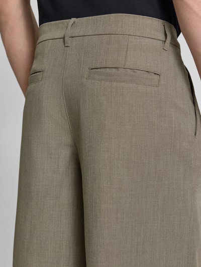 Männermodel trägt Bermudas mit Gesäßtaschen Modell 'Bin Guan' von WOODBIRD in Oliv, glatte Textur, Nahaufnahme Rückansicht, Relaxed Fit, Material-Mix mit Viskose-Anteil.