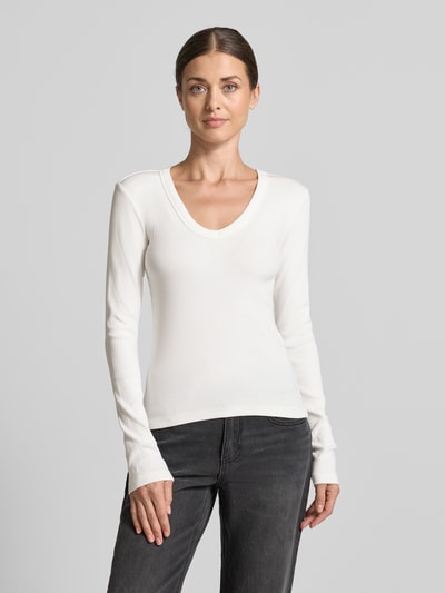 Frauenmodel trägt weißes Slim Fit Langarmshirt aus Baumwoll-Mix Modell 'CHLOE' von VERO MODA, kombiniert mit dunkler Jeans, Ganzkörperansicht von vorne. Damen Langarmshirt von VERO MODA.