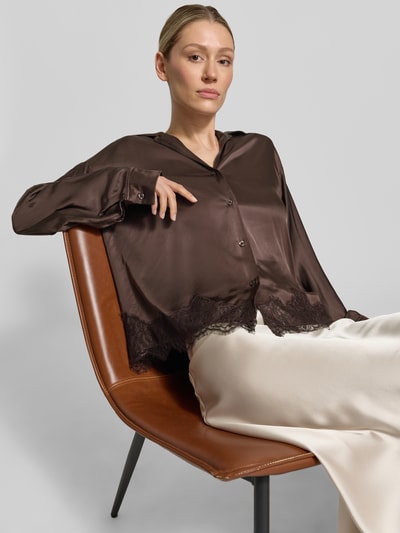 Frauenmodel trägt Relaxed Fit Bluse aus Viskose mit Spitzenbesatz von Jake*s Collection in Braun mit Reverskragen und V-Ausschnitt, Nahaufnahme Oberkörper. Rückenlänge 64 cm, Ärmellänge 55 cm, glatte und leicht glänzende Textur.