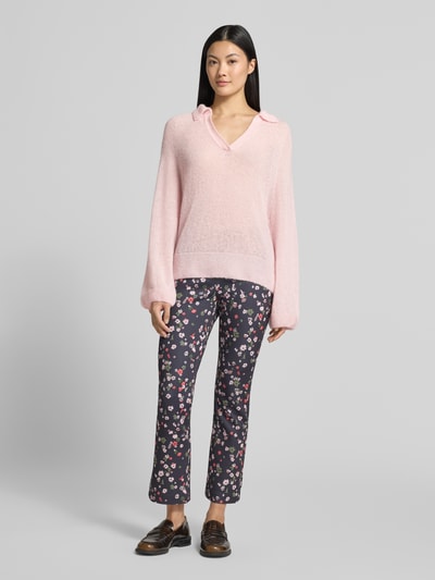 Kobiece modelka nosi Relaxed Fit Pullover aus Mohair-Alpaka-Mix von Marc Cain, jasnoróżowy, imitacja dzianiny, wykładany kołnierz z dekoltem w serek, z długim rękawem, długość tyłu w rozmiarze 36: 60 cm, długość rękawów w rozmiarze 36: 68 cm, Ganzkörperansicht von vorne.