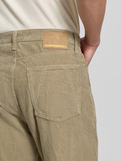 Männermodel trägt Wide Leg Cordhose aus Baumwoll-Mix Modell 'JAAMEO' von ARMEDANGELS in Beige, Herren Weite Hose, Nahaufnahme Rückansicht.