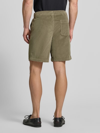 Mężczyzna nosi Regular Fit Sweatshorts aus Baumwoll-Mix von SELECTED HOMME w jednolitym oliwkowym kolorze, sztruks, krój regular fit, elastyczny ściągacz, tylna kieszeń naszywana, boczne kieszenie, bawełniany materiał, widok całej sylwetki od tyłu