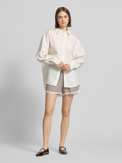 Vrouwenmodel draagt korte broek met kant, model 'ELIZA' van Noisy May, materiaalmix met katoen, regular fit, elastische band, bandwijdte maat S 38 cm, zwart-wit ruitmotief en witte kant, frontale lichaamsopname