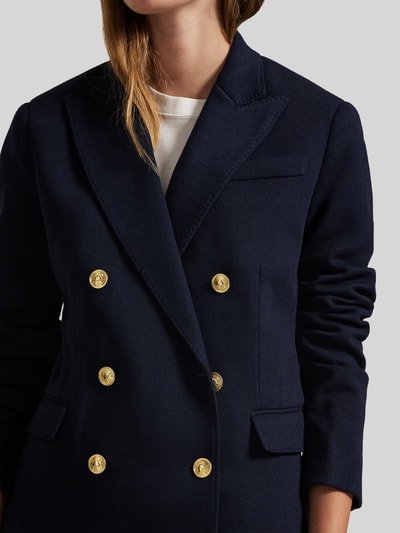 Frauenmodel trägt Zweireihiger Blazer mit Woll-Anteil von Polo Ralph Lauren in Dunkelblau mit goldenen Knöpfen, Nahaufnahme Oberkörper. Regular Fit, Reverskragen, Knopfverschluss, Brusttasche, Pattentaschen, Material-Mix.