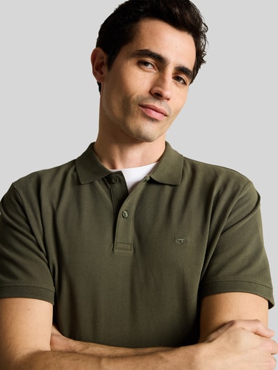 Männermodel trägt Regular Fit Poloshirt aus reiner Baumwolle von Tom Tailor, Optik: Unifarben, Materialverarbeitung: Piqué, Kurarm, Nahaufnahme Oberkörper.