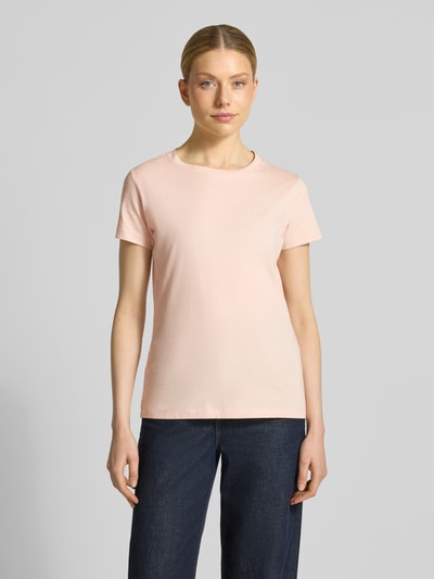 Frauenmodel trägt Regular Fit T-Shirt aus reiner Baumwolle Modell 'ESOGO' von BOSS Orange in zartem Rosa, unifarben, Rundhals, Label Schriftzug, kurzarm, Ganzkörperansicht von vorne.