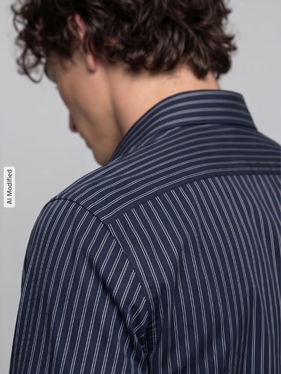Männermodel trägt Super Slim Fit Businesshemd aus Baumwoll-Mix von OLYMP No. Six in Dunkelblau mit weißen Streifen, Nahaufnahme Rückansicht, KI-modifiziertes Bild.
