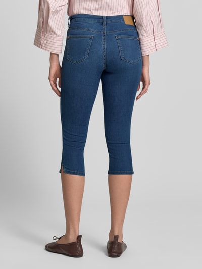 Frauenmodel trägt Slim Fit Caprijeans aus Baumwoll-Mix von Tom Tailor in klassischem Denim-Blau mit Logo Patch, 5-Pocket-Design, Ganzkörperansicht Rückansicht.