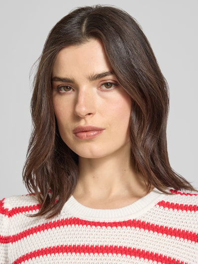 Frauenmodel trägt Strickshirt mit Rundhalsausschnitt Modell 'DALO' von Vila, Reine Baumwolle, Regular-Fit, Strukturmuster, Nahaufnahme Oberkörper.
