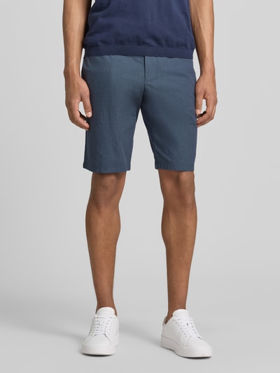 Männermodel trägt Bermudas mit Gürtel und Gesäßleistentaschen von Christian Berg Men aus Baumwoll-Mix mit Stretch-Anteil, Straight Fit, Knopf- und Reißverschluss, französischen Eingrifftaschen, Bundweite bei Größe 50: 45 cm, Innenbeinlänge 28 cm, Ganzkörperansicht von vorne.