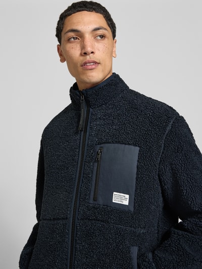 Männermodel trägt Regular Fit Teddy- / Webpelzjacke mit Brustleistentaschen von Marc O'Polo DENIM in Dunkelblau mit strukturierter Oberfläche, Nahaufnahme Oberkörper.