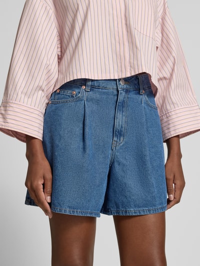 Frauenmodel trägt Jeansshorts mit Eingrifftaschen Modell 'GEMMA' von YAS aus Reine Baumwolle im Regular-Fit, Nahaufnahme Oberkörper. Bundweite bei Größe 36: 37 cm, Innenbeinlänge bei Größe 36: 41 cm.