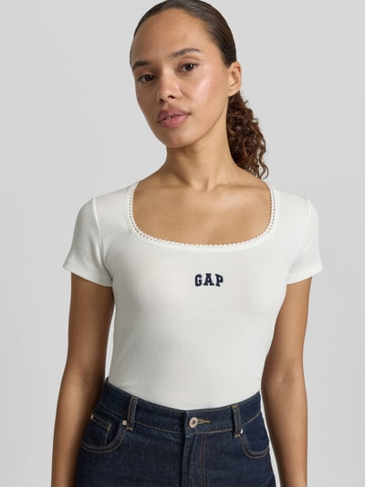 Frauenmodel trägt Damen T-Shirt mit Logo-Stitching von GAP aus Baumwoll-Mix mit Stretch-Anteil, körpernahe Passform, Rundhalsausschnitt, Rückenlänge bei Größe S 57 cm, Farbe Weiß, strukturierte Oberfläche, Nahaufnahme Oberkörper.