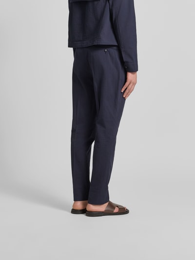 Mannenmodel draagt Straight Fit stoffen broek uit puur katoen van Officine Générale, band met haakjes- en ritssluiting, stolpplooi, steek- en achterzakken, binnenbeenlengte maat 50 79 cm, bandwijdte maat 50 45 cm, donkerblauw, Ganzkörperansicht Rückansicht.