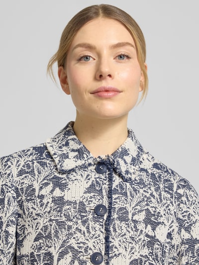 Vrouwenmodel draagt Slim Fit Blazer im Allover-Look mit Pattentaschen van WHITE LABEL, blauw-wit met platte kraag en knoopsluiting, detailopname bovenlichaam.