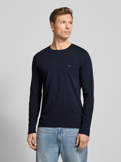 Männermodel trägt Slim Fit T-Shirt aus Baumwoll-Mix von Tommy Hilfiger, Optik: Unifarben, Label-Stitching-Applikation, Rundhals, Langarm, Jersey, Ganzkörperansicht von vorne.