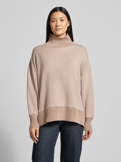 Kobiece model nosi bluza 'Sweatshirt mit Stehkragen und überschnittenen Schultern' od VARLEY, mieszanka wiskozy z dodatkiem streczu, krój relaxed fit, stójka, obniżone ramiona, kolor beżowy, tekstura dzianinowa. Widok całej sylwetki z przodu.