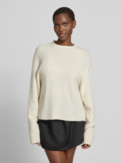 Frauenmodel trägt Regular Fit Pullover aus Alpaka-Mix von black palms in Creme mit Strick-Optik, Rundhalsausschnitt, elastische Abschlüsse, Rückenlänge bei Größe S 60 cm, Ganzkörperansicht von vorne.