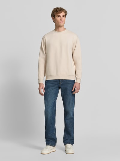 Mannenmodel draagt Slim Fit Pullover uit pure katoen 'TOM' van Selected, heren sweatshirt in beige met blauwe denim, volledig vooraanzicht.