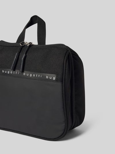 Produktfoto, Kulturtasche mit Label-Details Modell 'Blanc Delight' von bugatti in Schwarz, Hauptfach mit Reißverschluss, Tragehenkel, strukturierte Oberfläche, Maße 25x23x8 cm, Schulterriemen 16 cm.