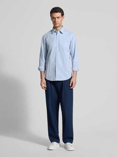 Männermodel trägt Regular Fit Freizeithemd aus Baumwoll-Mix Modell 'RELEGANT_6_M' von BOSS Orange, hellblau, gepunktet, Ganzkörperansicht von vorne.