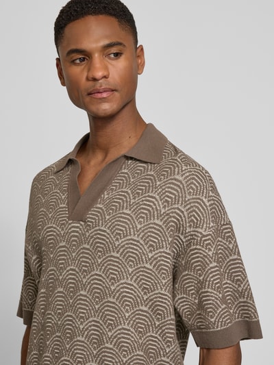 Männermodel trägt Relaxed Fit Poloshirt mit V-Ausschnitt Modell 'LAURENZZO' von Drykorn im Allover-Look aus Baumwoll-Mix, Nahaufnahme Oberkörper. Rückenlänge bei Größe M: 67 cm.