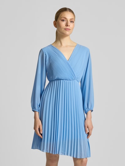 Frauenmodel trägt Knielanges Kleid mit Plisseefalten Modell 'Im44sa' von ZABAIONE, Wickel-Optik, Taillierter Schnitt, Ganzkörperansicht von vorne.