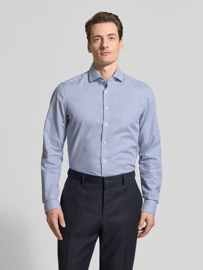 Męski model nosi Body Fit Business-Hemd mit Kentkragen von OLYMP Level Five, niebiesko-białe paski, czysta bawełna, krój body fit, długość tyłu w rozmiarze 40L: 83 cm, szerokość ramion w rozmiarze 40L: 44 cm, długość rękawa w rozmiarze 40L: 72 cm, widok całej sylwetki z przodu.