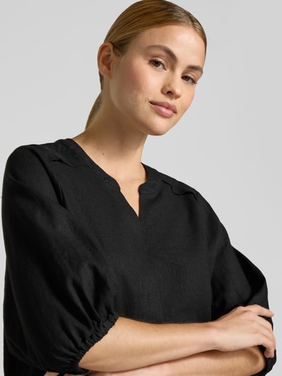 Frauenmodel trägt Bluse aus Leinen-Mix mit verlängertem Rücken Modell 'Lava' von FREE/QUENT, schwarz, locker geschnitten, Nahaufnahme Oberkörper. Damenbluse aus Leinen-Mix mit Viskose-Anteil, Tunika-Ausschnitt, 3/4-Arm, elastischer Abschluss, verlängerter Rücken.