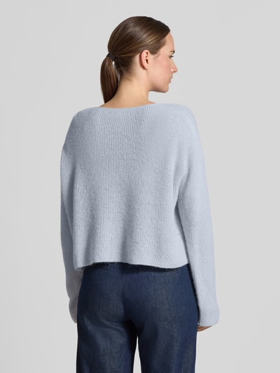 Frauenmodel trägt Oversized Wollpullover aus Alpaka-Mix von DRYKORN in Hellgrau, Ripp-Optik, weite Schultern, Rückenansicht, Ganzkörperansicht Rückansicht.