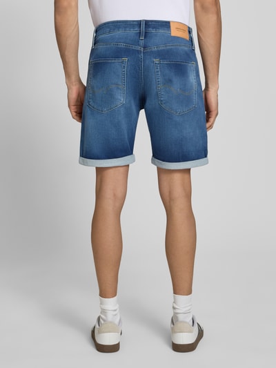 Mężczyznamodel nosi Regular Fit Jeansshorts mit Umschlag Modell 'RICK' von Jack & Jones w niebieskim odcieniu, bawełniany mix z dodatkiem wiskozy, używany wygląd, szerokość w rozmiarze M 42 cm, długość wewnętrzna nogawki 20 cm, widok całej sylwetki od tyłu