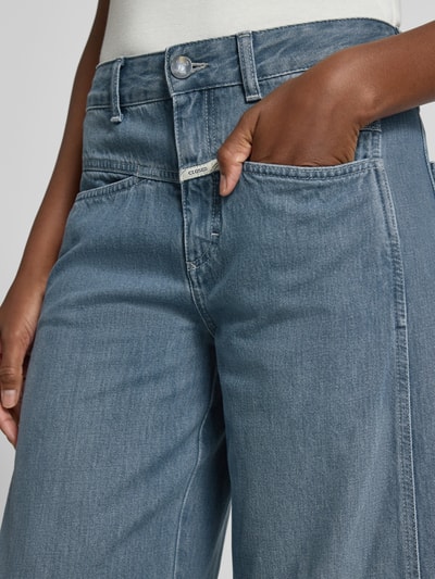 Kobieta nosi jeansy Barrel Fit Jeans mit Label-Detail Modell 'TORI-X' od Closed z bawełny, wpuszczane kieszenie; zbliżenie na biodra