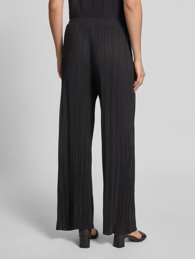 Frauenmodel trägt Wide Leg Hose mit Plisseefalten Modell 'PLISA' von Vila aus schwarzem Material-Mix mit Viskose-Anteil, Ganzkörperansicht Rückansicht.