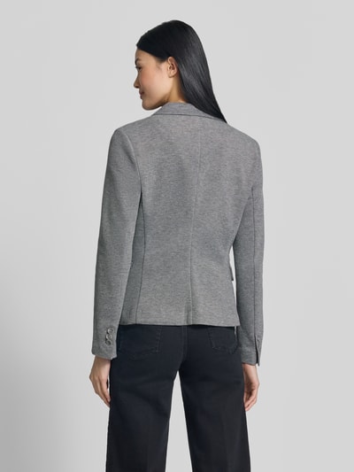 Vrouwenmodel draagt Slim Fit Kurzblazer met katoenmix model 'JULIA' van VERO MODA in grijs, rechte lijnen, effen textuur, volledige lichaamsfoto achteraan.